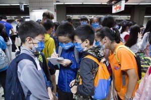 參加科普列車活動的學生在月台等待列車時，拿著筆記本討論實驗內容。（黃子明攝）